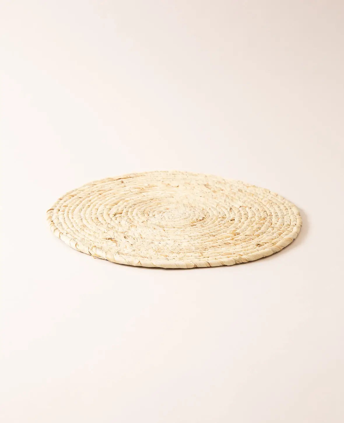 Round placemat made of braided natural fibers