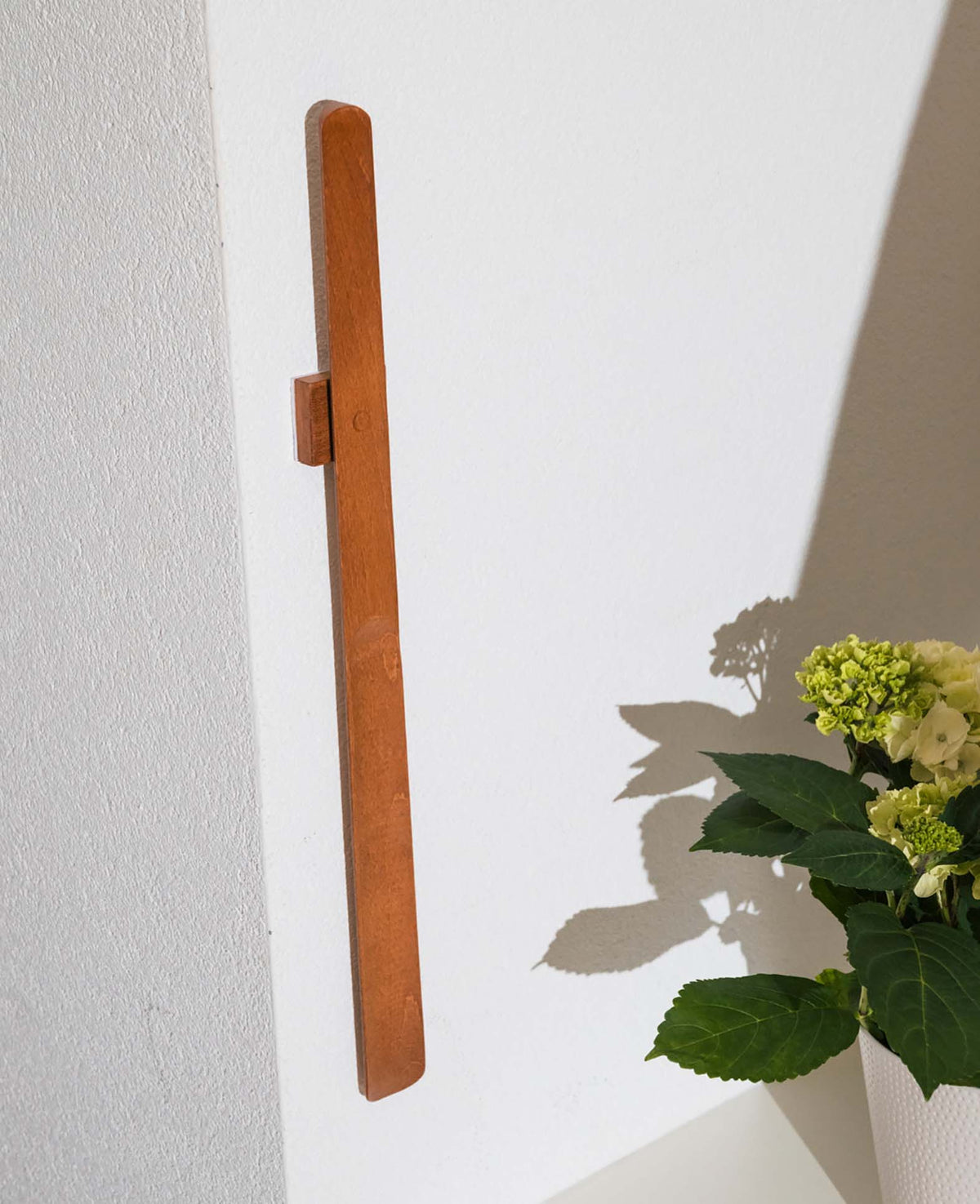 Long beechwood shoehorn with magnetic wall mount